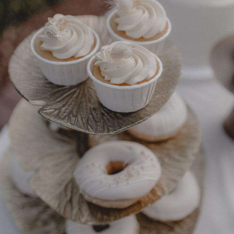 Weiße Cupcakes und Donuts auf einer Etagere