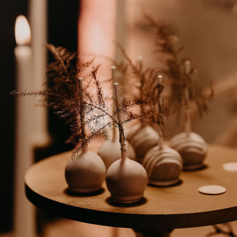 Cake Pops mit Schokoladenüberzug auf einem Holztablett