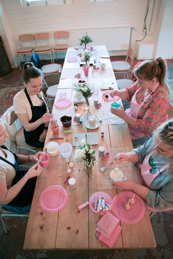 Teilnehmerinnen eines Workshops an einer langen gedeckten Tafel